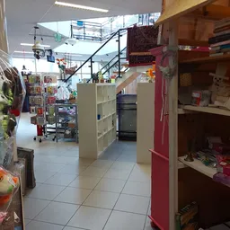 Winkelinterieur met stellingen, rekken en trap; zichtbaar aanbod van diverse tweedehandsartikelen