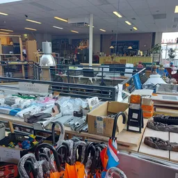 Overzicht van de winkelvloer met diverse uitgestalde spullen, stellingen en artikelen in een kringloopwinkel