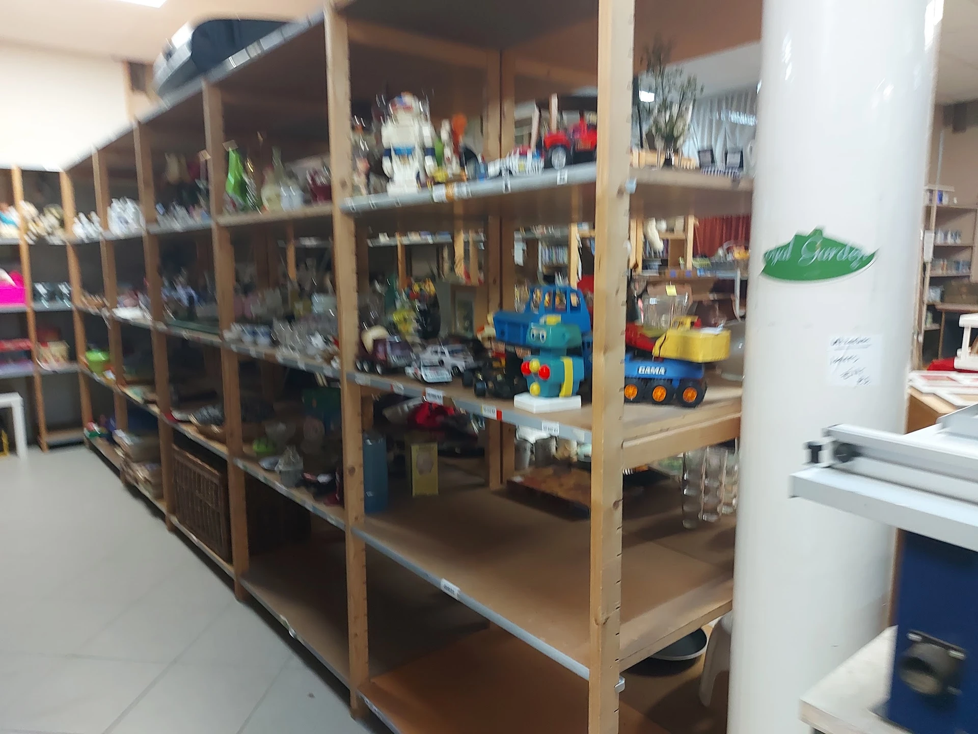 Houten stellingen met diverse artikelen in een kringloopwinkel