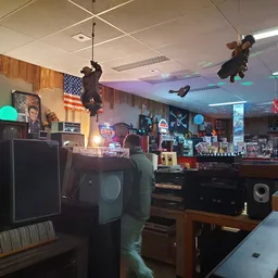 Interieur van kringloopwinkel met elektronicaartikelen, speakers, audio-apparatuur en diverse spullen op stellingen en tafels