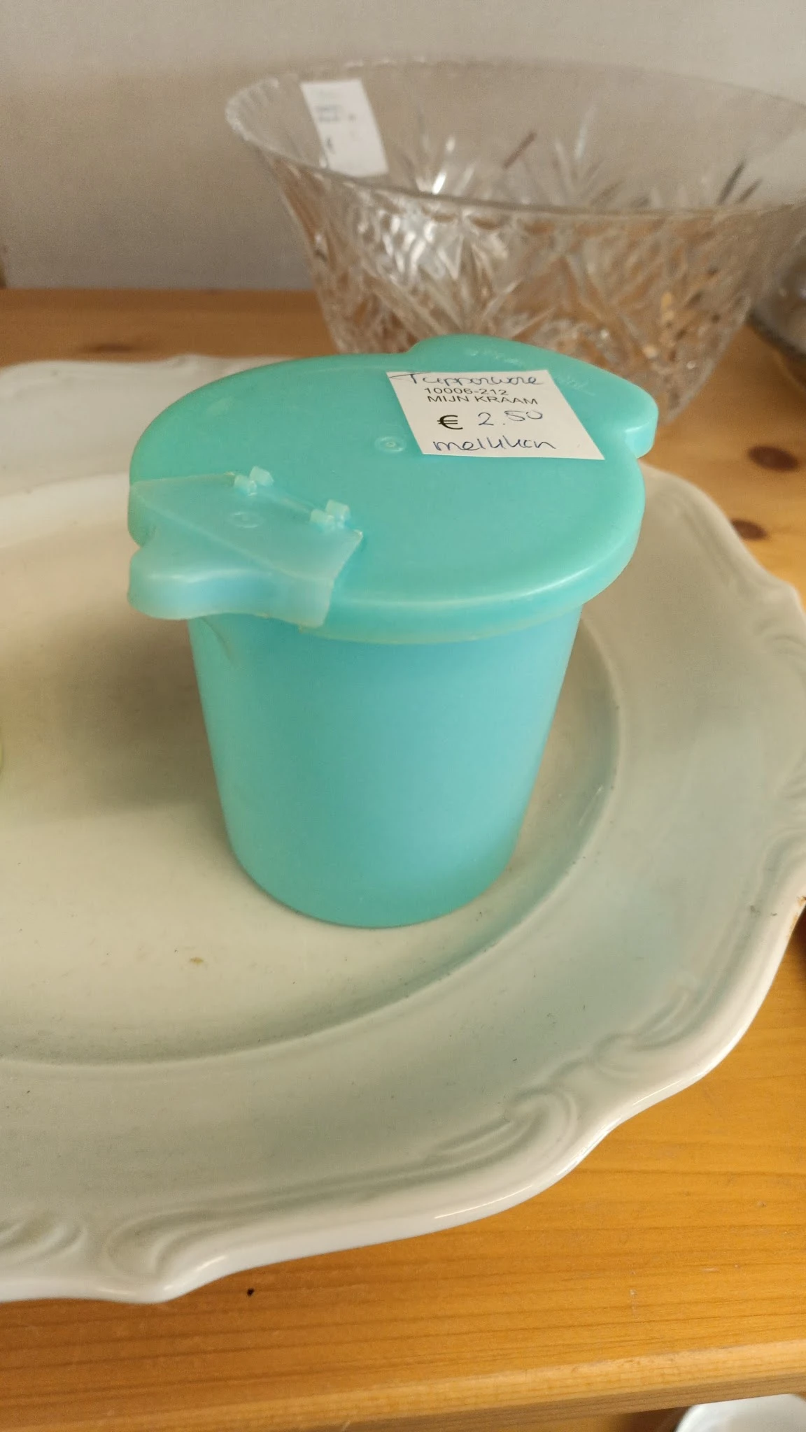 Turquoise plastic container met deksel op een witte ondergrond