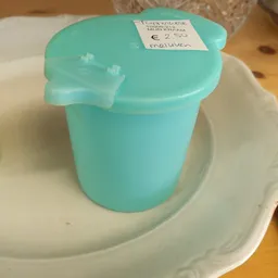 Turquoise plastic container met deksel op een witte ondergrond