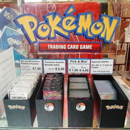 Uitstalling van Pokémon Trading Card Game producten in een kringloopwinkel met boosterpacks en kaarten in verschillende dozen