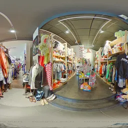 Overzicht van kringloopwinkel met kledingrekken, boeken en speelgoed verspreid over de winkelruimte