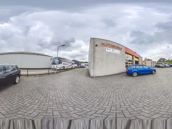 Exterieur van autohandelsbedrijf met parkeerplaats, geparkeerde auto's en bedrijfsgebouwen