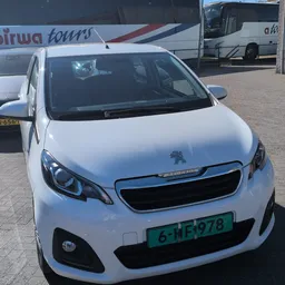 Witte Peugeot 108 personenauto met Nederlands kenteken, voorzijde zichtbaar op parkeerterrein