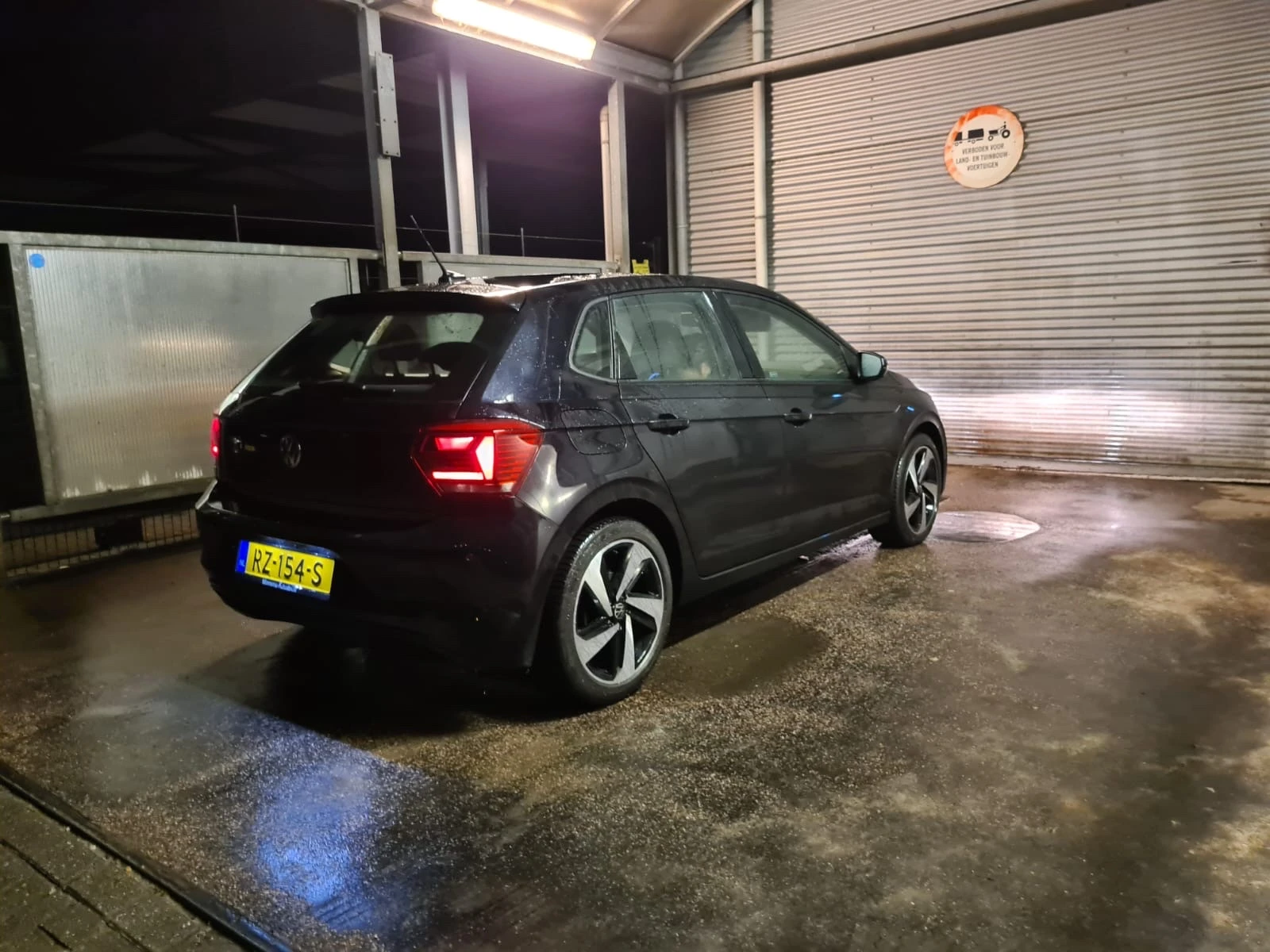 Zwarte Volkswagen Golf elektrische auto in showroom, zijkant zichtbaar met verlichte interieur