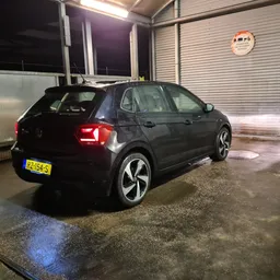Zwarte Volkswagen Golf elektrische auto in showroom, zijkant zichtbaar met verlichte interieur
