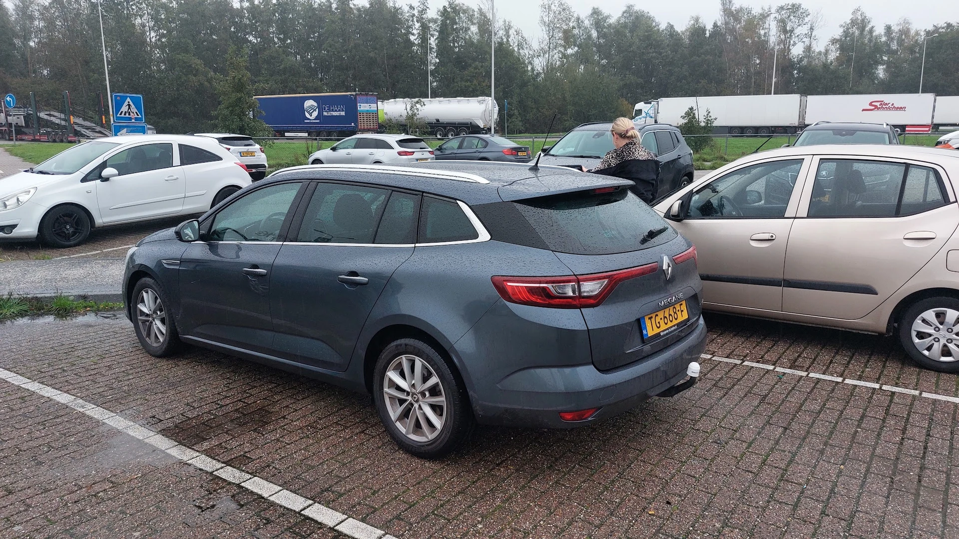 Tweedehands Renault Mégane Estate in blauwe kleur op het parkeerterrein tussen andere auto's