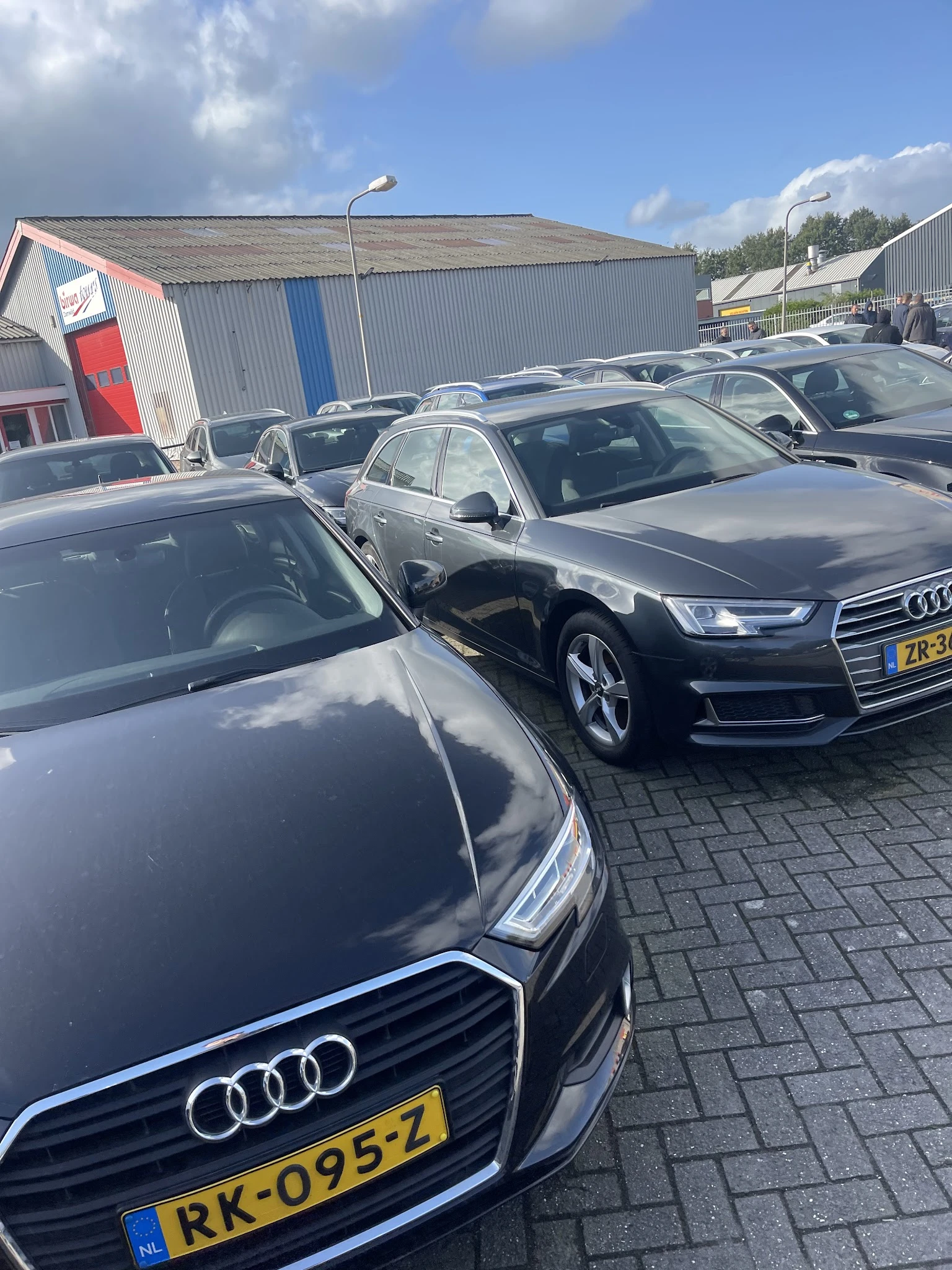 Tweedehands Audi-auto's op het terrein van een autobedrijf, geparkeerd op kasseien