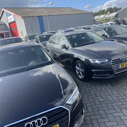 Tweedehands Audi-auto's op het terrein van een autobedrijf, geparkeerd op kasseien