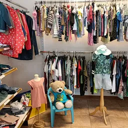 Tweedehands kinderkleding en speelgoed in een kringloopwinkel met rekken, stellingen enDisplayItems