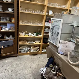 Houten kastjes en stellingen met serviesgoed, borden, glazen en huishoudartikelen in de winkel