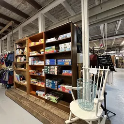 Houten stellingkast met bordspellen, boeken en speelgoed netjes uitgestald in de winkel