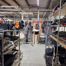 Winkelvloer met stellingen vol kinderartikelen, fietsen en speelgoed in een kringloopwinkel