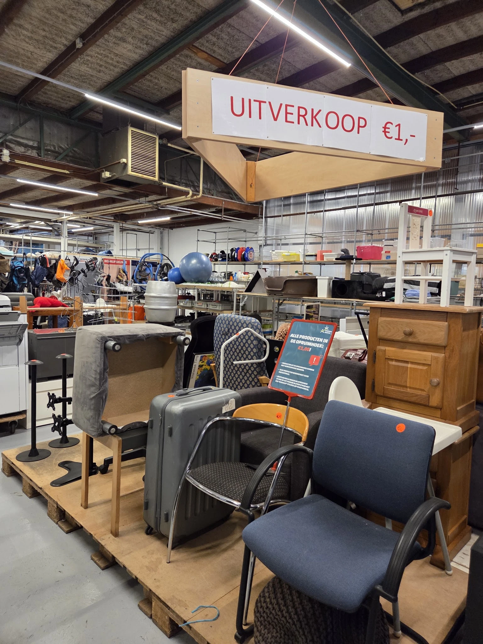Uitgestalde tweedehands koffers, tassen en huishoudartikelen in de kringloopwinkel
