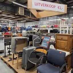 Uitgestalde tweedehands koffers, tassen en huishoudartikelen in de kringloopwinkel