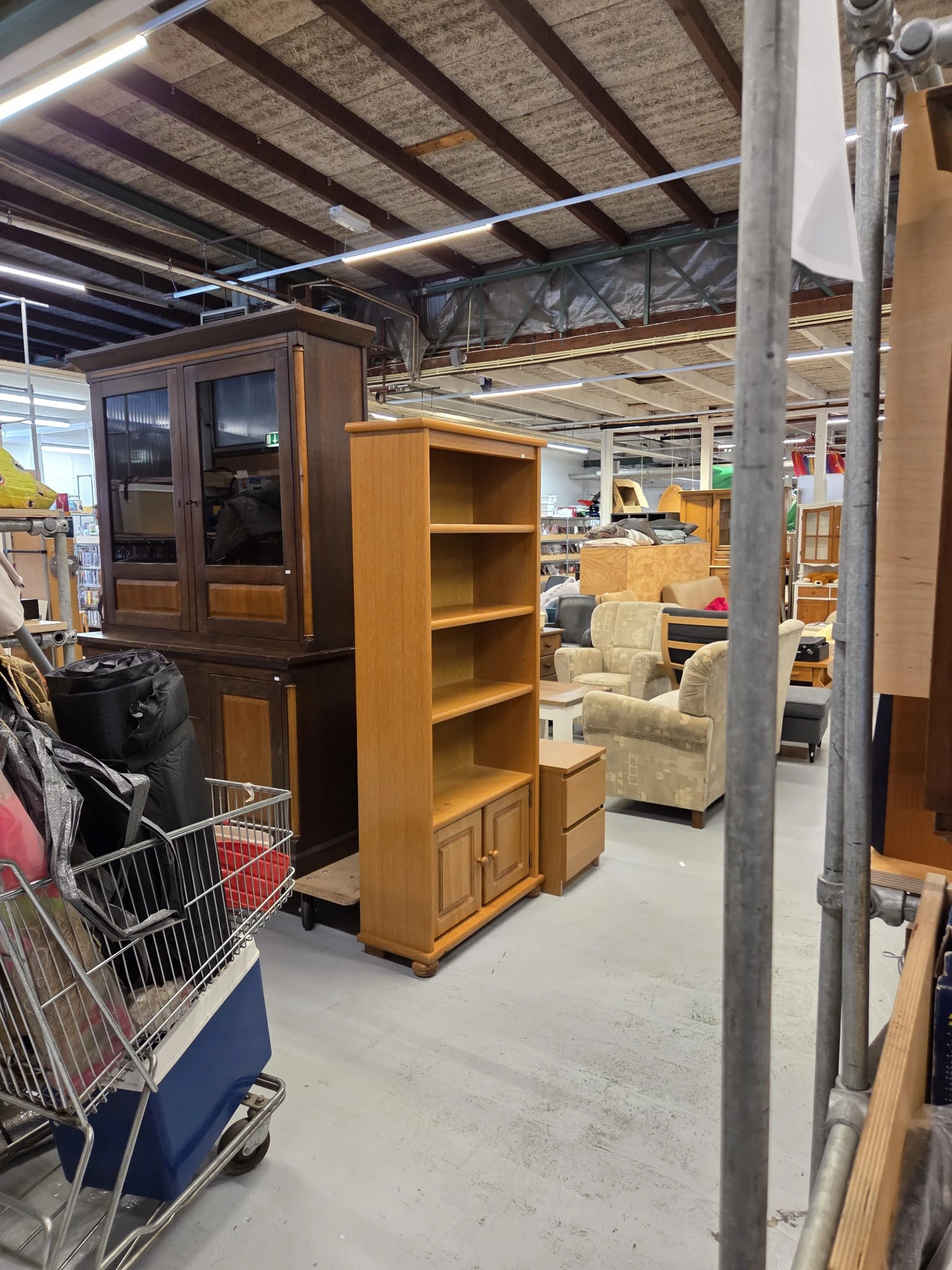 Tweedehands meubels in kringloopwinkel: houten kasten, boekenkast en fauteuils