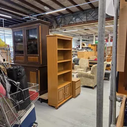 Tweedehands meubels in kringloopwinkel: houten kasten, boekenkast en fauteuils
