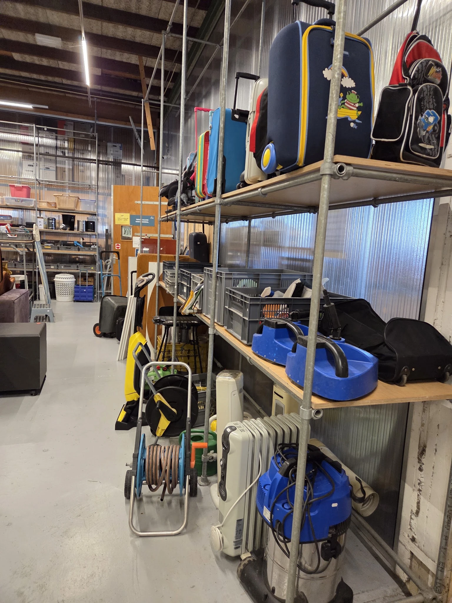 Winkelvloer met stellingen vol spullen, tassen, fietsen en diverse tweedehands artikelen