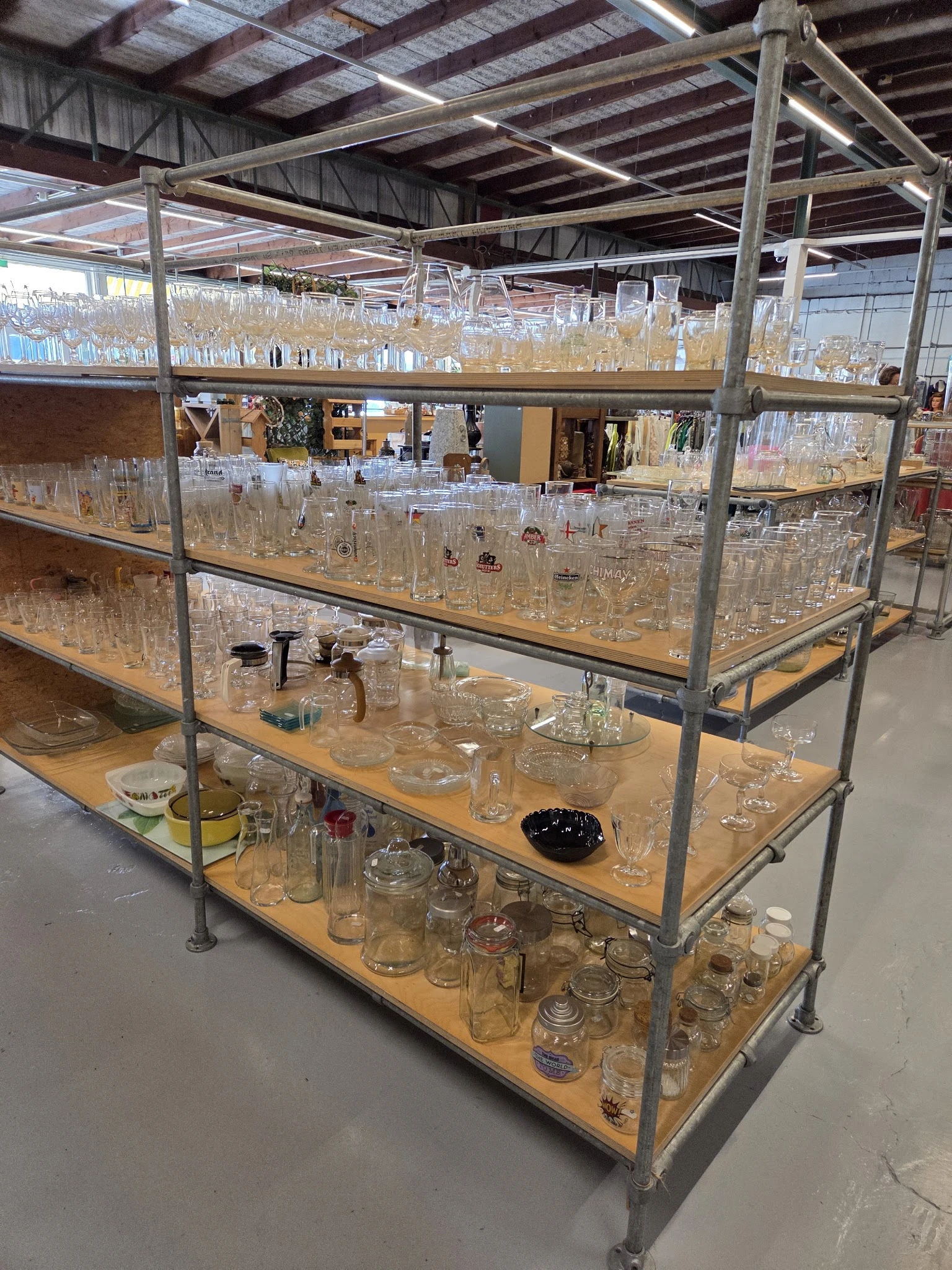 Glazen kasten met verschillende glazen potten, vazen en drinkglazen uitgestald