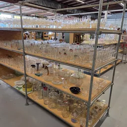 Glazen kasten met verschillende glazen potten, vazen en drinkglazen uitgestald