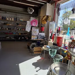 Winkelvloer van kringloopwinkel met stellingen, uitgestalde artikelen en diverse spullen