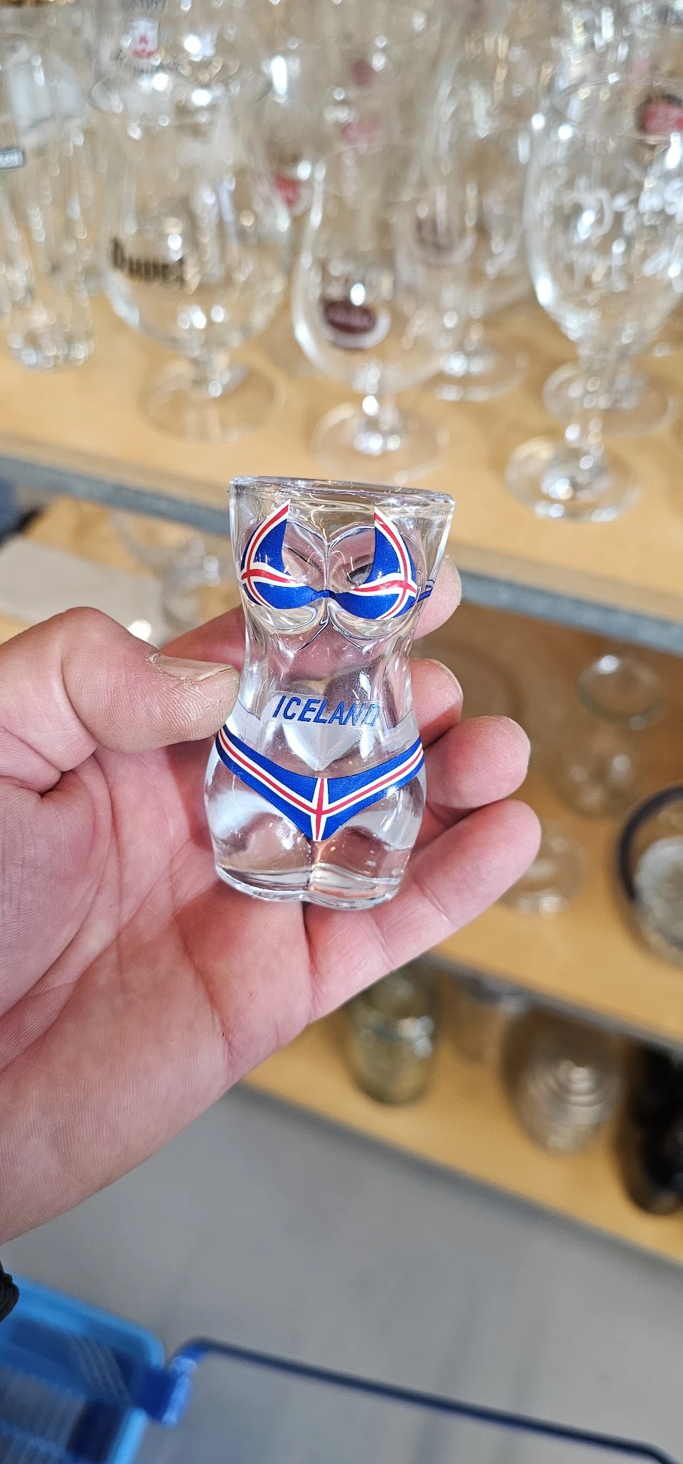 Shotglas met IJslandse vlag en opdruk 'ICELAND' in hand