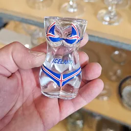 Shotglas met IJslandse vlag en opdruk 'ICELAND' in hand