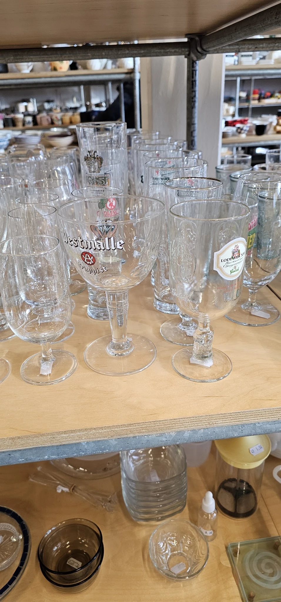 Verzameling glazen met logo's van verschillende merken op een houten tafel