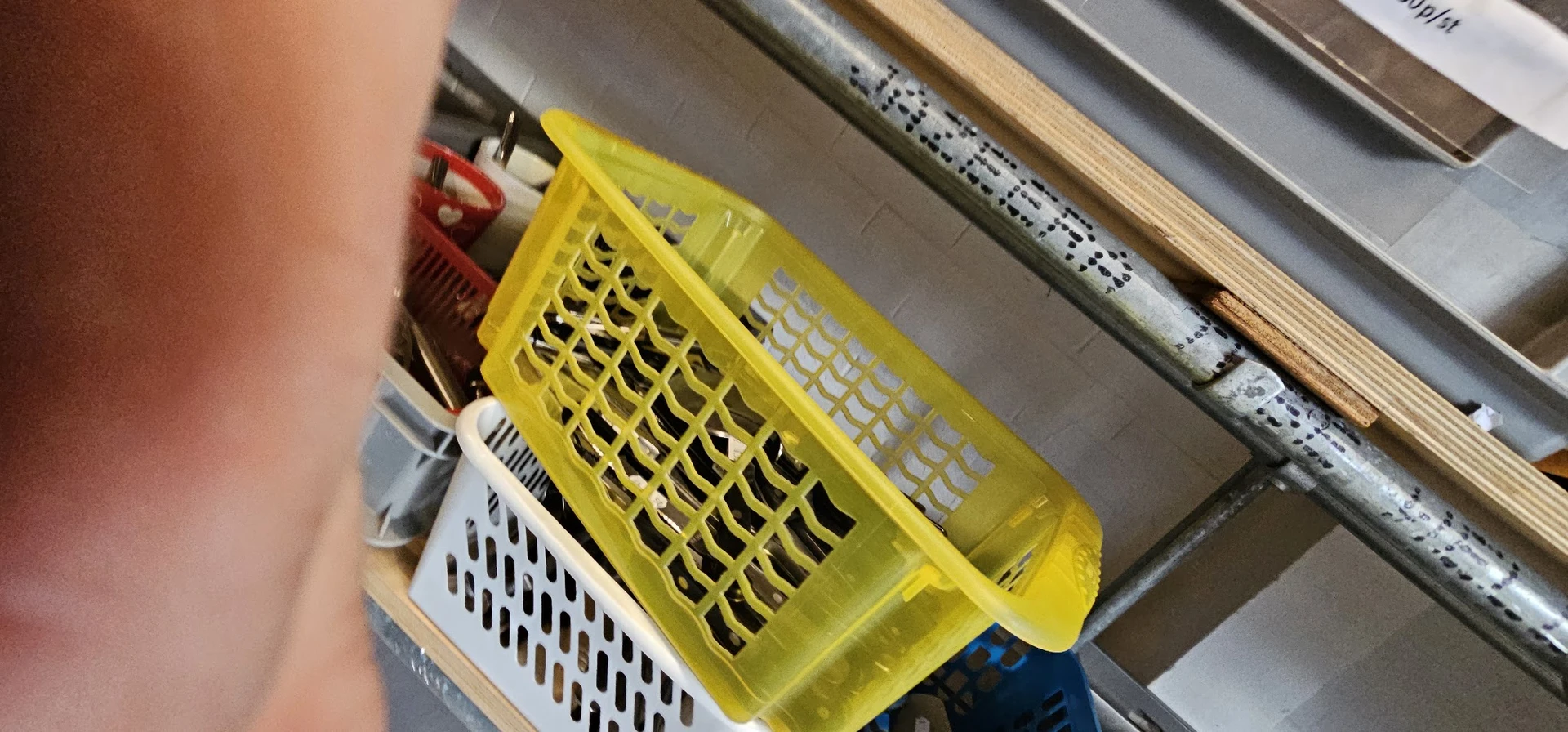 Gele plastic manden en witte stapelbare kratten in een kringloopwinkel