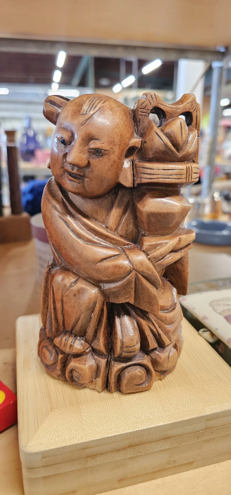 Houten beeldje van een lachende man met een grote buik, hand aan hoofd, handgemaakt kunstwerk