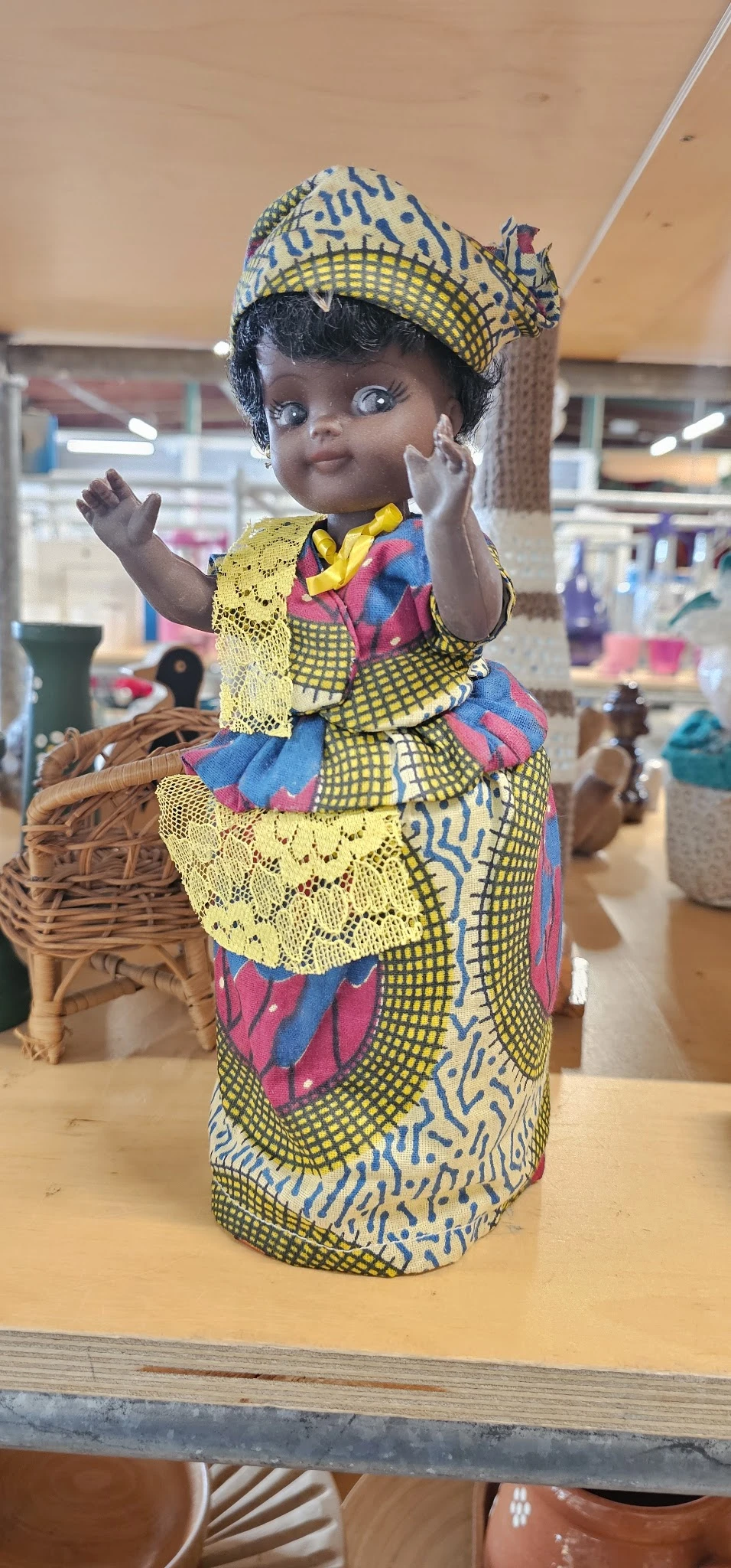 Afrikaanse pop met kleurrijke traditionele klederdracht en gele kanten details