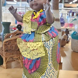Afrikaanse pop met kleurrijke traditionele klederdracht en gele kanten details