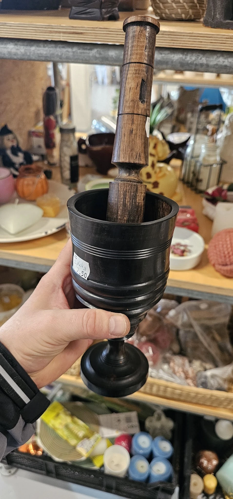 Close-up van een zwarte mortelaar met zware stenen stamper in een hand