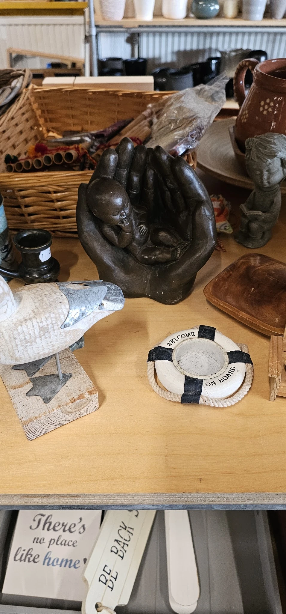 Diverse decoratieve artikelen op tafel: beeldhouwwerk, decoratieve vissen, lifebuoy-object en houten schaaltje