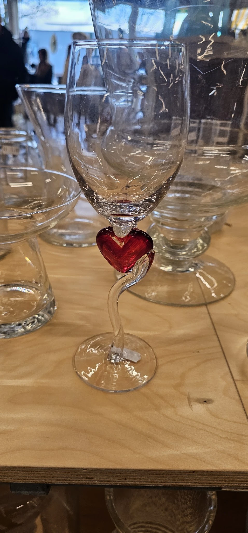 Glazen decoratieobject met rood hartvormig element tussen glaswerk