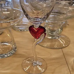 Glazen decoratieobject met rood hartvormig element tussen glaswerk