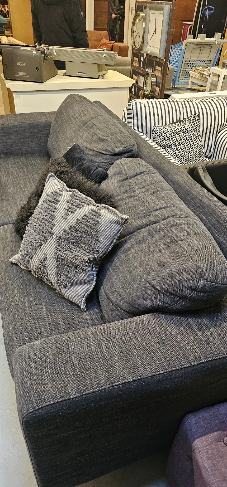 Grijze stoffering met decoratief kussen op grijze bank of zetel