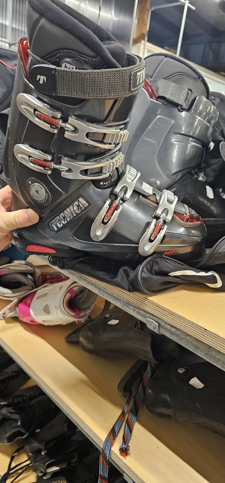 Close-up van tweedehands ski- en snowboardschoenen in zwart met rode accenten