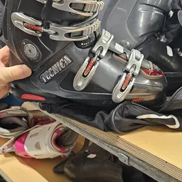 Close-up van tweedehands ski- en snowboardschoenen in zwart met rode accenten
