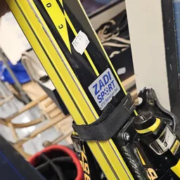 Close-up van een zwart-geel mountainbike frame met Zadi Sport sticker en onderdelen