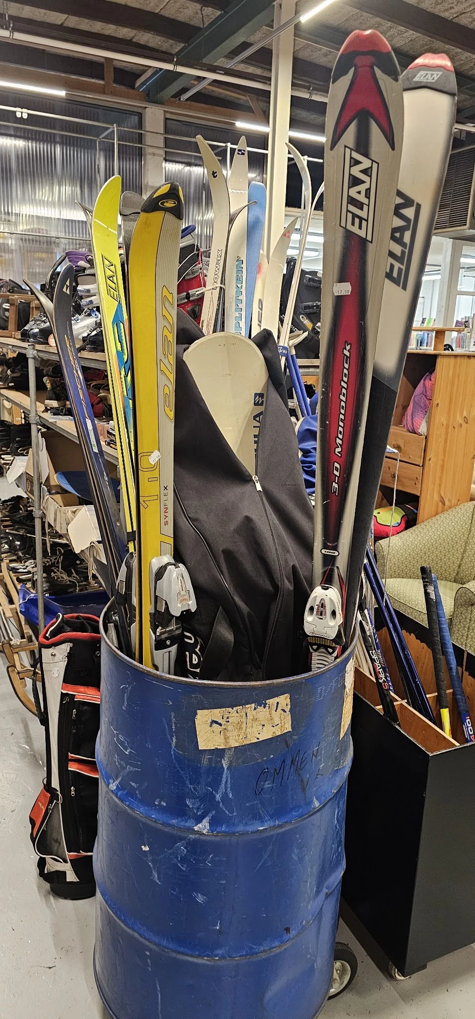 Ski's en snowboards opgesteld in een emmer in de winkelruimte