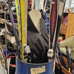 Ski's en snowboards opgesteld in een emmer in de winkelruimte
