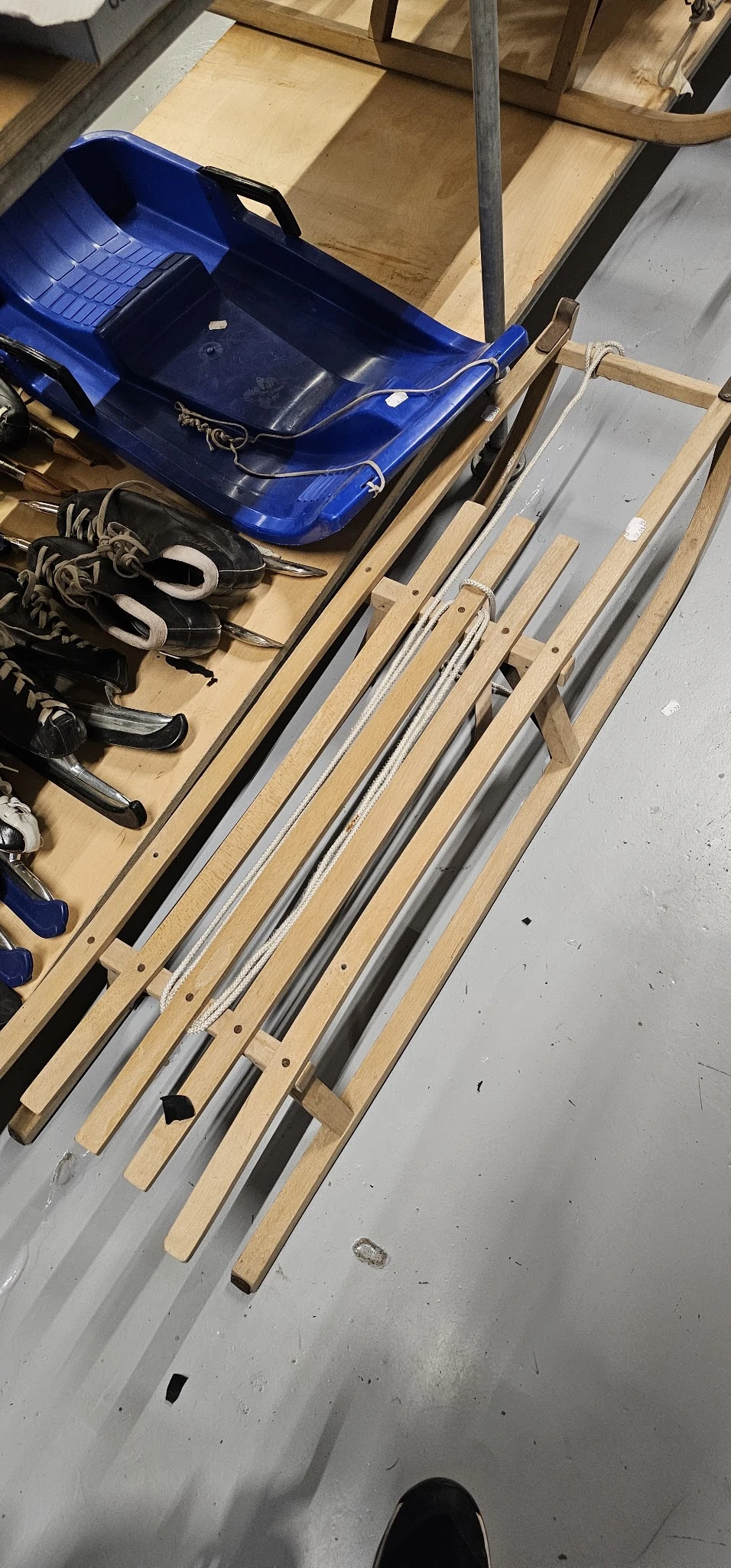 Diverse pijpen en buizen in metaal en kunststof op houten stellingen, met schoenen en ander materiaal