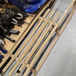 Diverse pijpen en buizen in metaal en kunststof op houten stellingen, met schoenen en ander materiaal