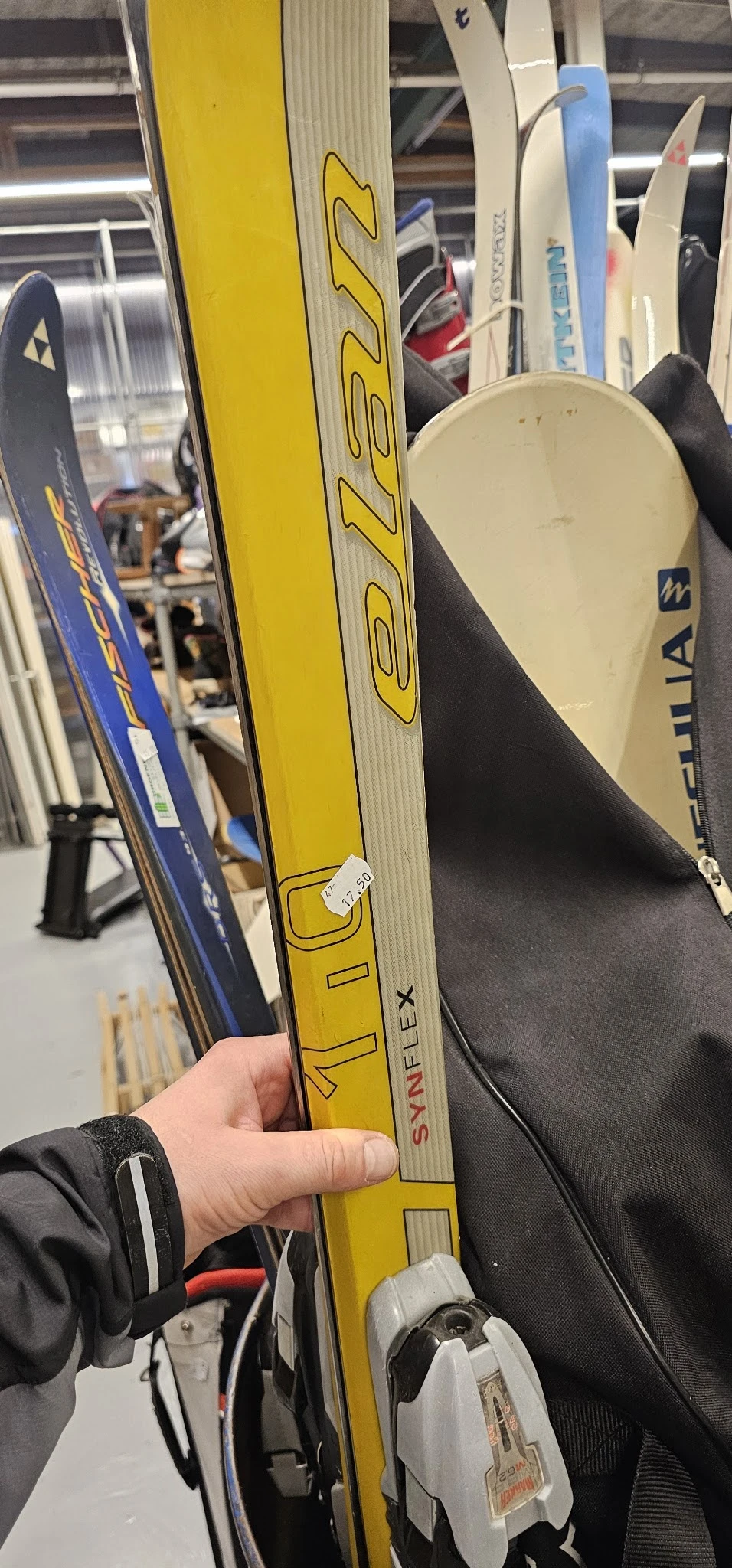 Close-up van gele ski's met zwarte bindingen, gestapeld naast blauwe ski's