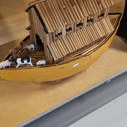 Miniatuurnschip met gele romp en houten details op display