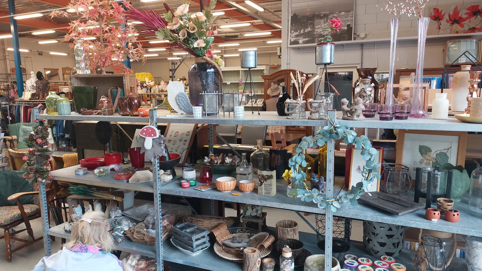 Stellingen met diverse huishoudartikel, decoratie, bloemen en interieurstukken in de kringloopwinkel