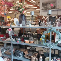 Stellingen met diverse huishoudartikel, decoratie, bloemen en interieurstukken in de kringloopwinkel
